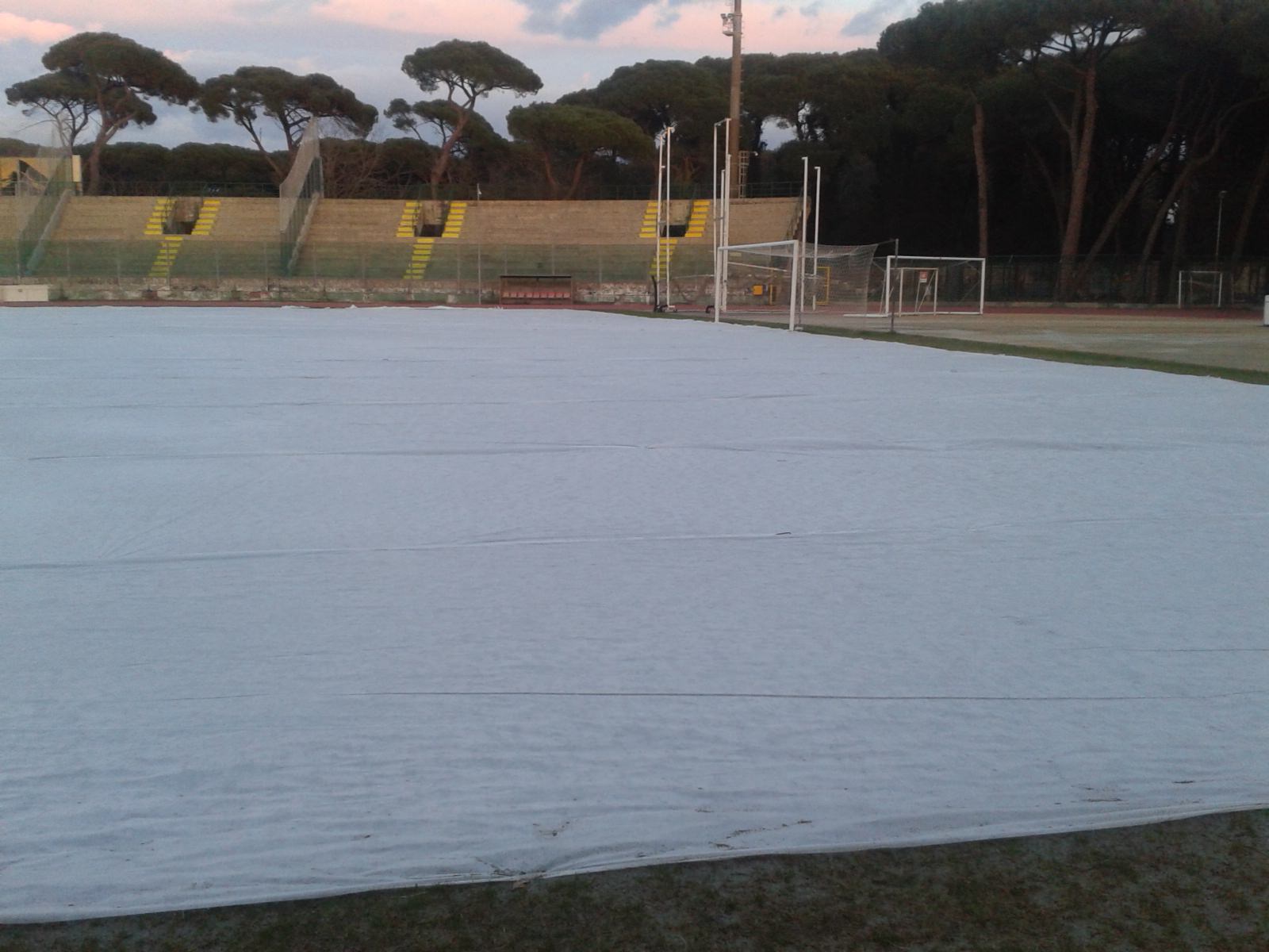 Un telo bianco a protezione del terreno dello stadio