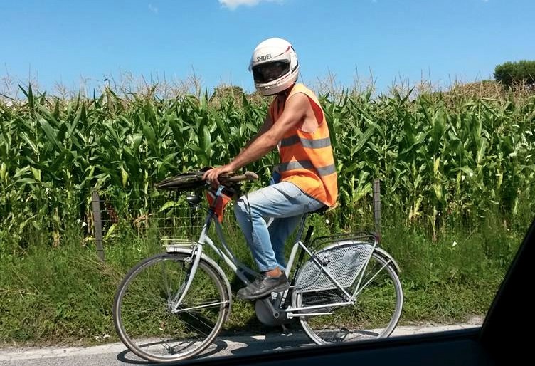In bici con casco integrale e ombrello, scoppia l’ilarità sul web (foto)
