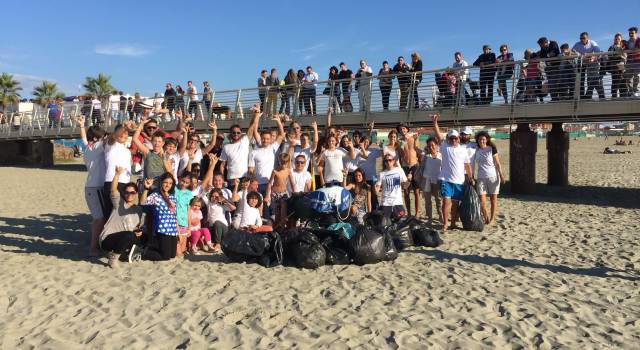 Adulti e bambini ripuliscono la spiaggia di Lido