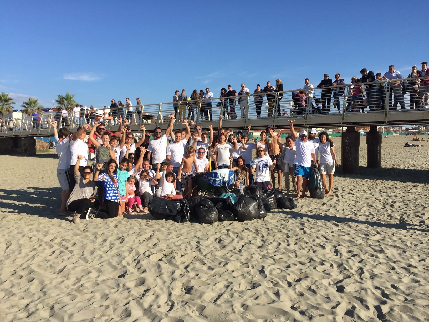 Adulti e bambini ripuliscono la spiaggia di Lido