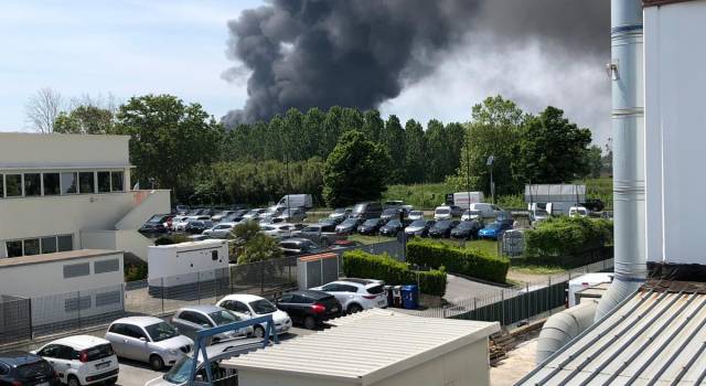 Capannone a fuoco, la densa nube di fumo nero visibile anche dal porto